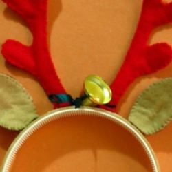 A headband that looks like reindeer antlers and ears with a decorative bell. 