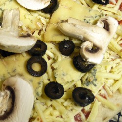 A cheese pizza with toppings added