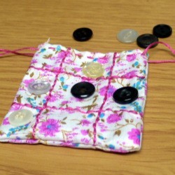 Fabric and Button Tic-Tac-Toe Game - finished game pouch with two markers on board