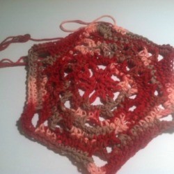A dishcloth made from croched yarn in a flower shape.