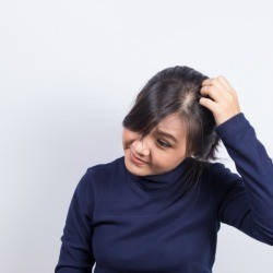A woman scratching her head.