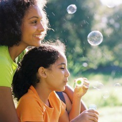 Mother and daughter blowing bubbles. 