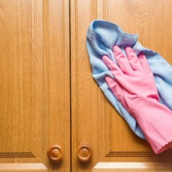 Cleaning a wood cabinet.