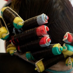 A woman in the middle of getting a perm at a salon.