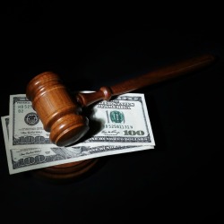 A judge's gavel on top of hundred dollar bills.