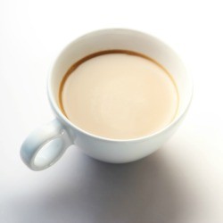 A cup of coffee with cream in it.