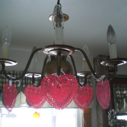 Heart Doily Valentine Decoration - red paper heart doilies hanging from light fixture