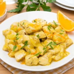 A dish of orange chicken on a table.