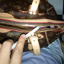 A candle being used to lubricate the zipper of a purse.