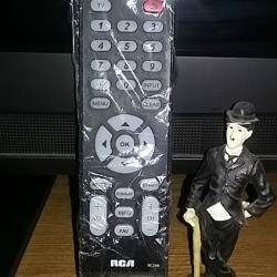 A television remote control covered in plastic wrap.