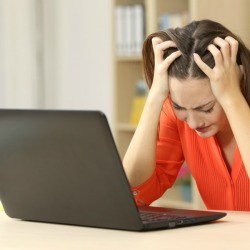 A frustrated woman looking at her laptop computer.