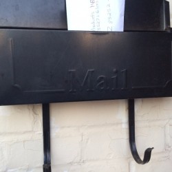 An open mailbox next to a front door.
