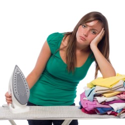 Frustrated woman holding a steam iron that won't produce steam.