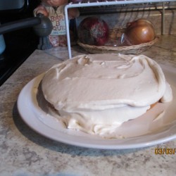 A homemade cake with frosting on a plate.