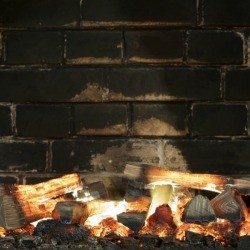 A fireplace with soot on the bricks.