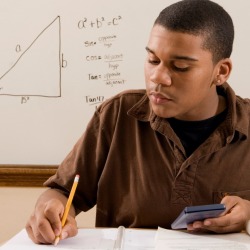 A young man studying for his math class.