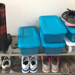 Shoes on a rack and in plastic shoe boxes.