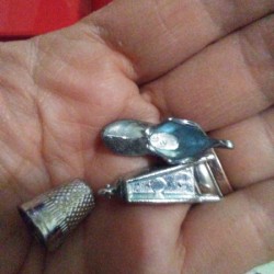 A boot, wheelbarrow and thimble Monopoly pieces.