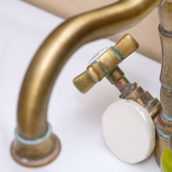Antique faucet with green stains.