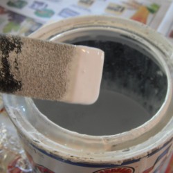 A sponge paintbrush with paint on the tip.