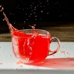 Cup of Kool-Aid splashing out onto the table.