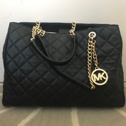 A filled hangbag that is sitting upright.