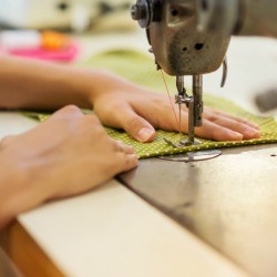 Using a sewing machine to sew using a tablecloth as fabric.