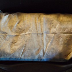 A polypropylene bag that has been turned into a dog mattress.