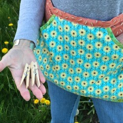 Clothespin Apron - person wearing the apron and holding a couple of clothes pins