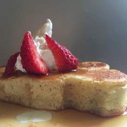Japanese Style Puff Pancakes on plate with fruit, syrup and whipped cream
