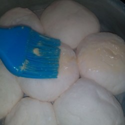 brushing bread balls with egg