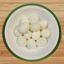 A bowl of peeled hard boiled eggs.