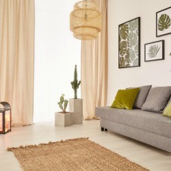 A nicely decorated living room with a gray couch and green accents.