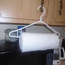 A roll of paper towels on a plastic clothes hanger.