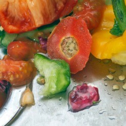 Vegetable scraps in a sink with a garbage disposal.