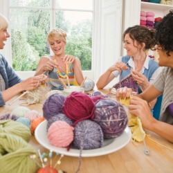A group of friends knitting projects for charity.