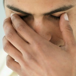 A man touching his eye lid.