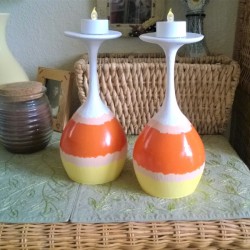 Wine glasses painted to resemble candy corn, placed upside down with battery operated candles inside.