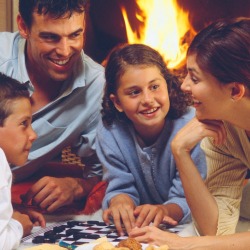 Family Playing Checkers by Fire