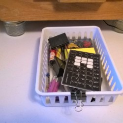 A basket that can slide underneath a storage drawer.