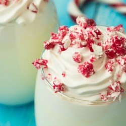 Glass of Candy Cane Ice Cream Punch topped with candy cane pieces.