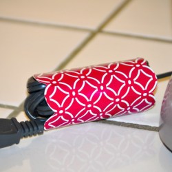 A piece of recycled cardboard from a tissue box, wrapped around an appliance cord.