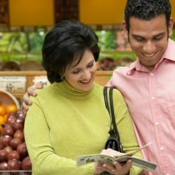 Woman and Man Looking at Coupons in Supermarket