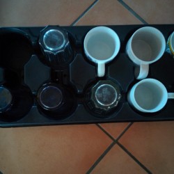A plant tray being reused for coffee mugs and glassware.