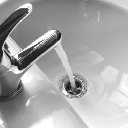 Closeup of porcelain sink with running water.