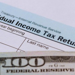 Tax Return Form with One Hundred Dollar Bill