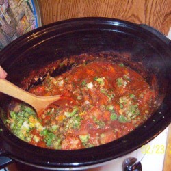 A crockpot of spaghetti sauce made with juiced vegetables.