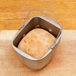 Bread in bread machine on wooden board