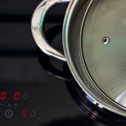 Glass Top Stove with a pot and a lid.