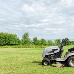 Riding lawn mower in a grassy field.